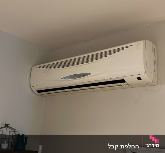 מזגן קיר לבן מותקן על הקיר בחדר